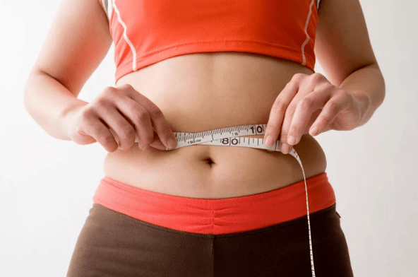 The girl measures the amount of waist