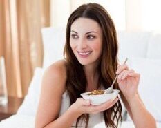 The girl eats buckwheat porridge